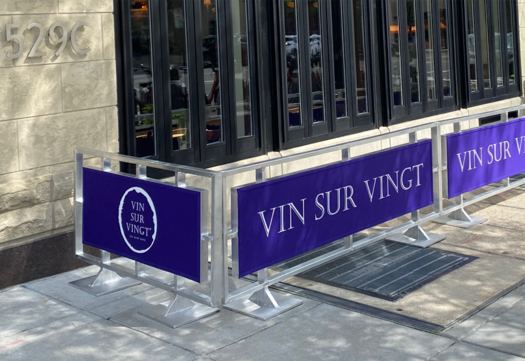 Custom branded sidewalk cafe barrier around an outdoor dining area